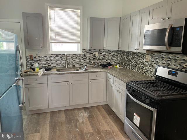 a kitchen with granite countertop a sink stove and cabinets