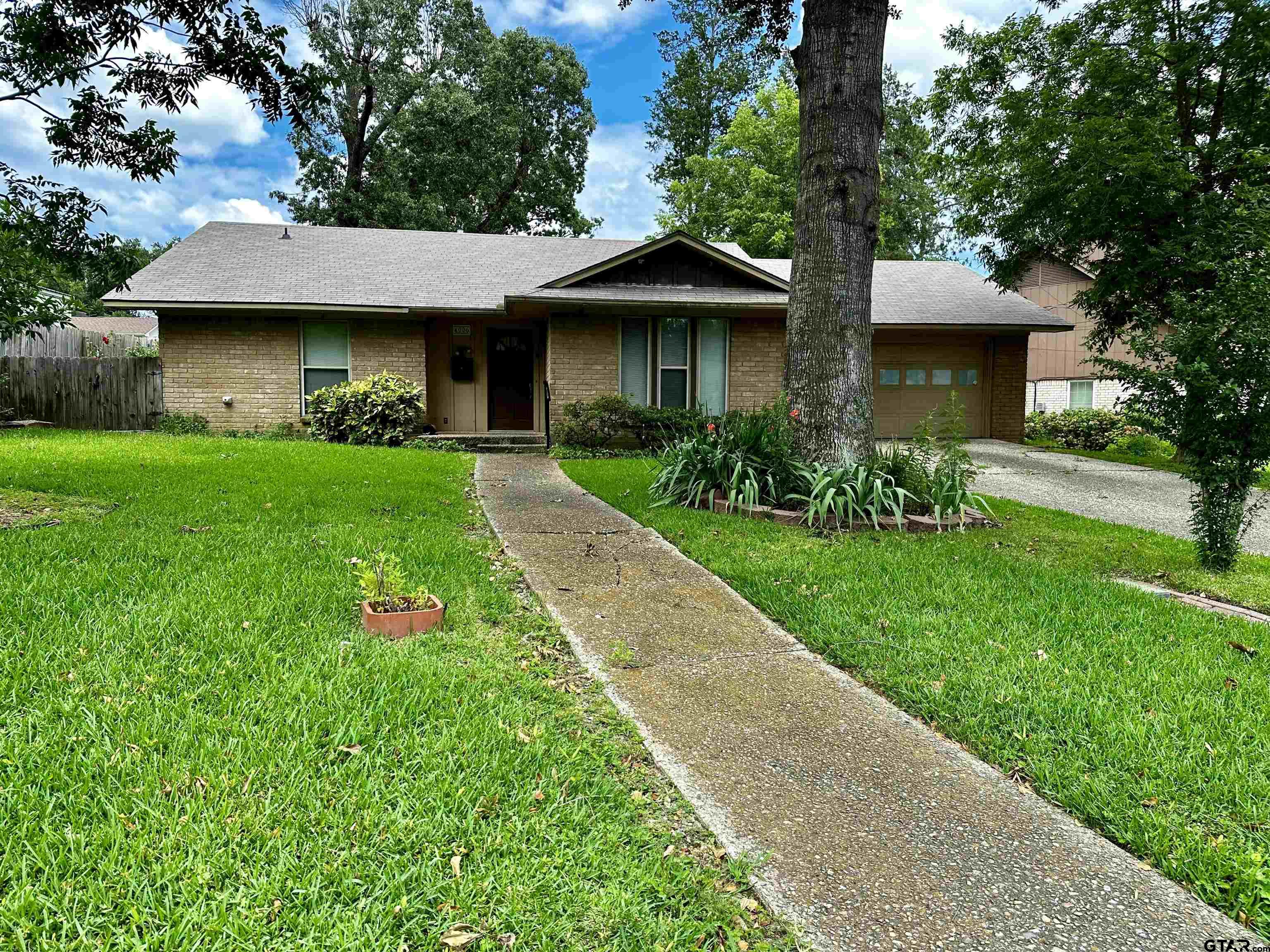 a front view of a house with a garden and yard