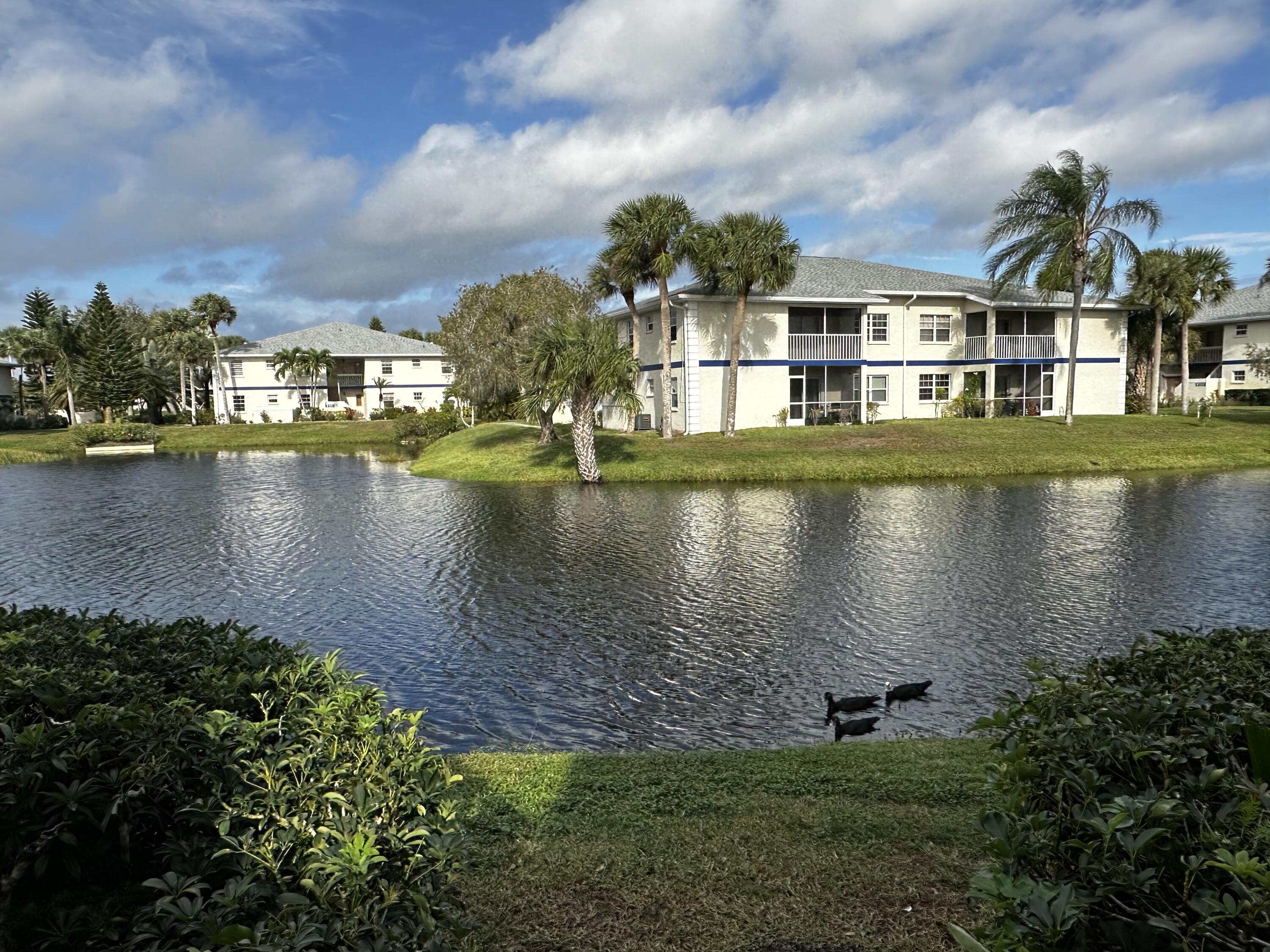 an aerial view of residential houses with outdoor space and lake view