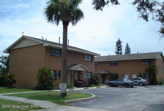 a front view of a house with a garden and plants