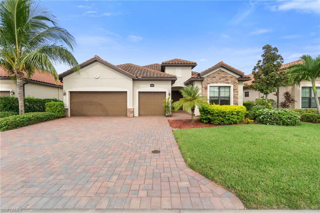 Mediterranean / spanish-style house featuring a front lawn and a garage