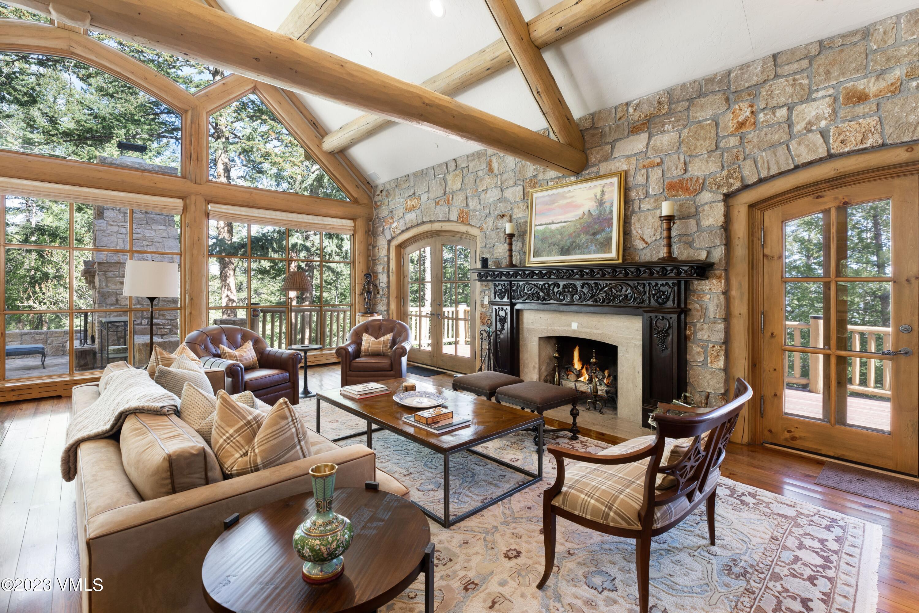 a living room with furniture a fireplace and a floor to ceiling window