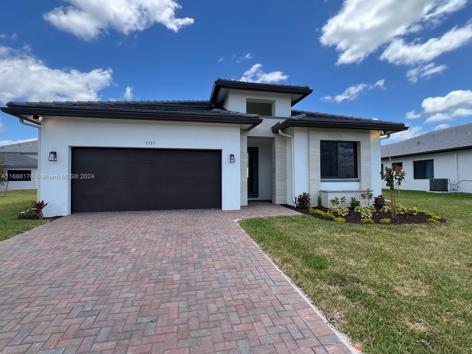 a front view of a house with a yard and garage