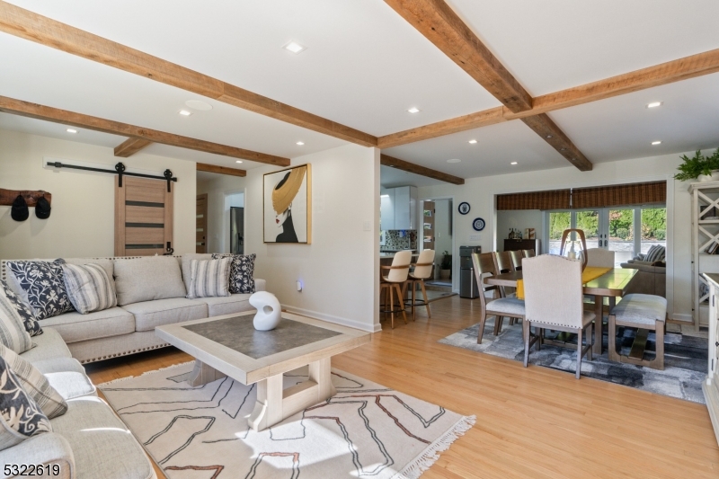 a living room with furniture a rug and a view of kitchen