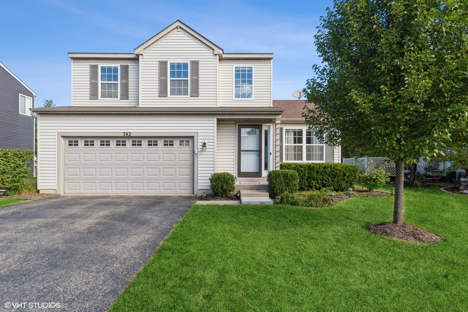 a front view of a house with a yard and garage