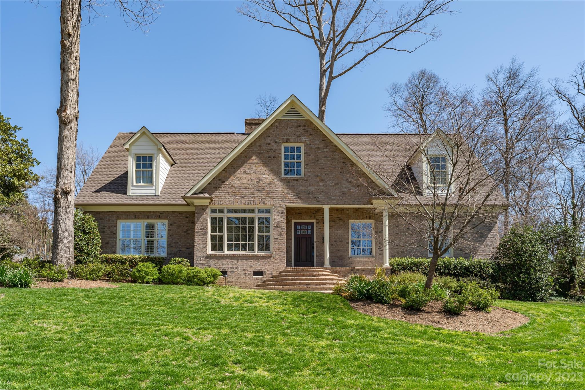 a front view of a house with a yard and trees