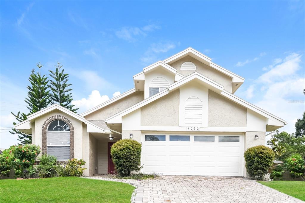 a front view of a house with a yard and garage