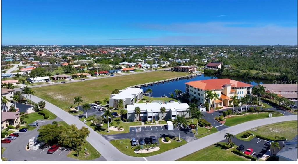 an aerial view of a city with lots of residential buildings ocean and mountain view in back