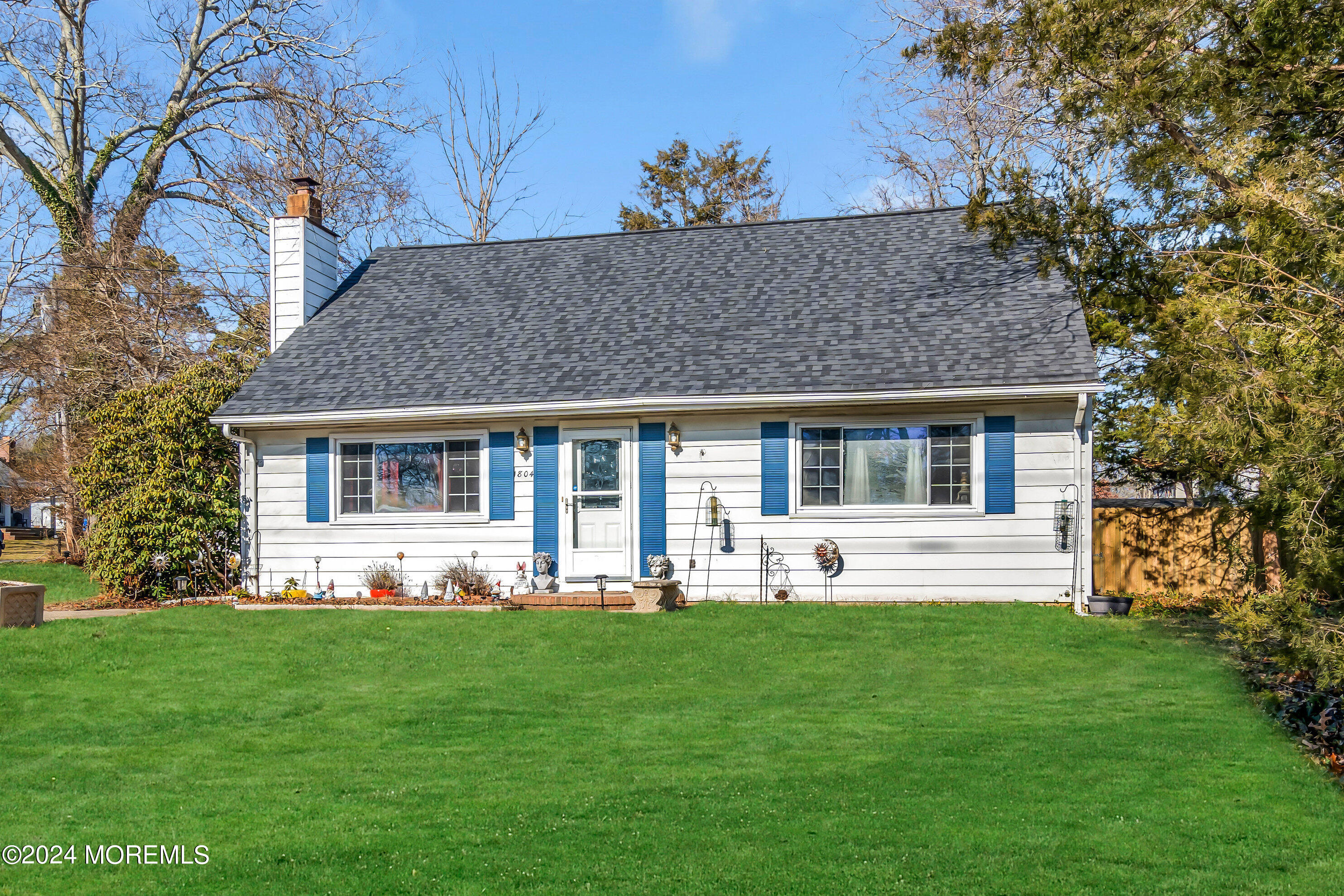 a front view of house with a garden and trees