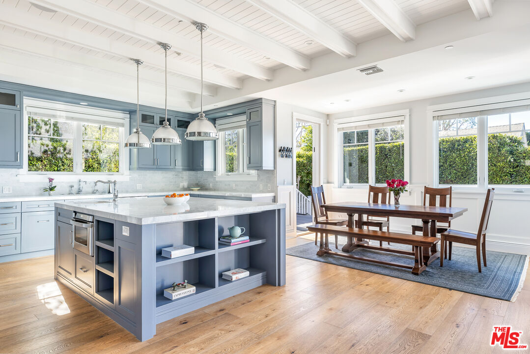 a view of kitchen with stainless steel appliances granite countertop center island and living room view