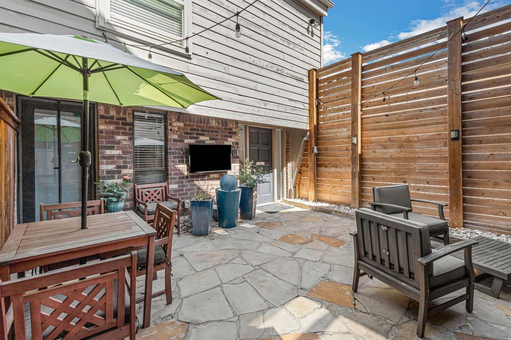 a view of a patio with a table and chairs under an umbrella