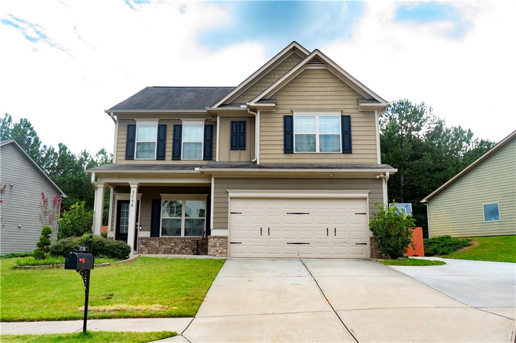 a front view of a house with a yard and garage