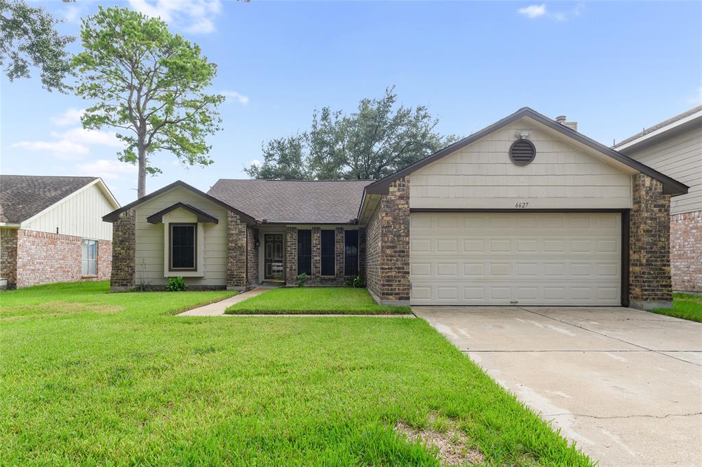 a front view of house with yard and garage