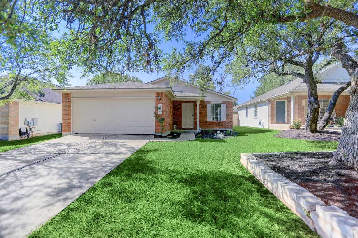 a view of a house with yard and a tree