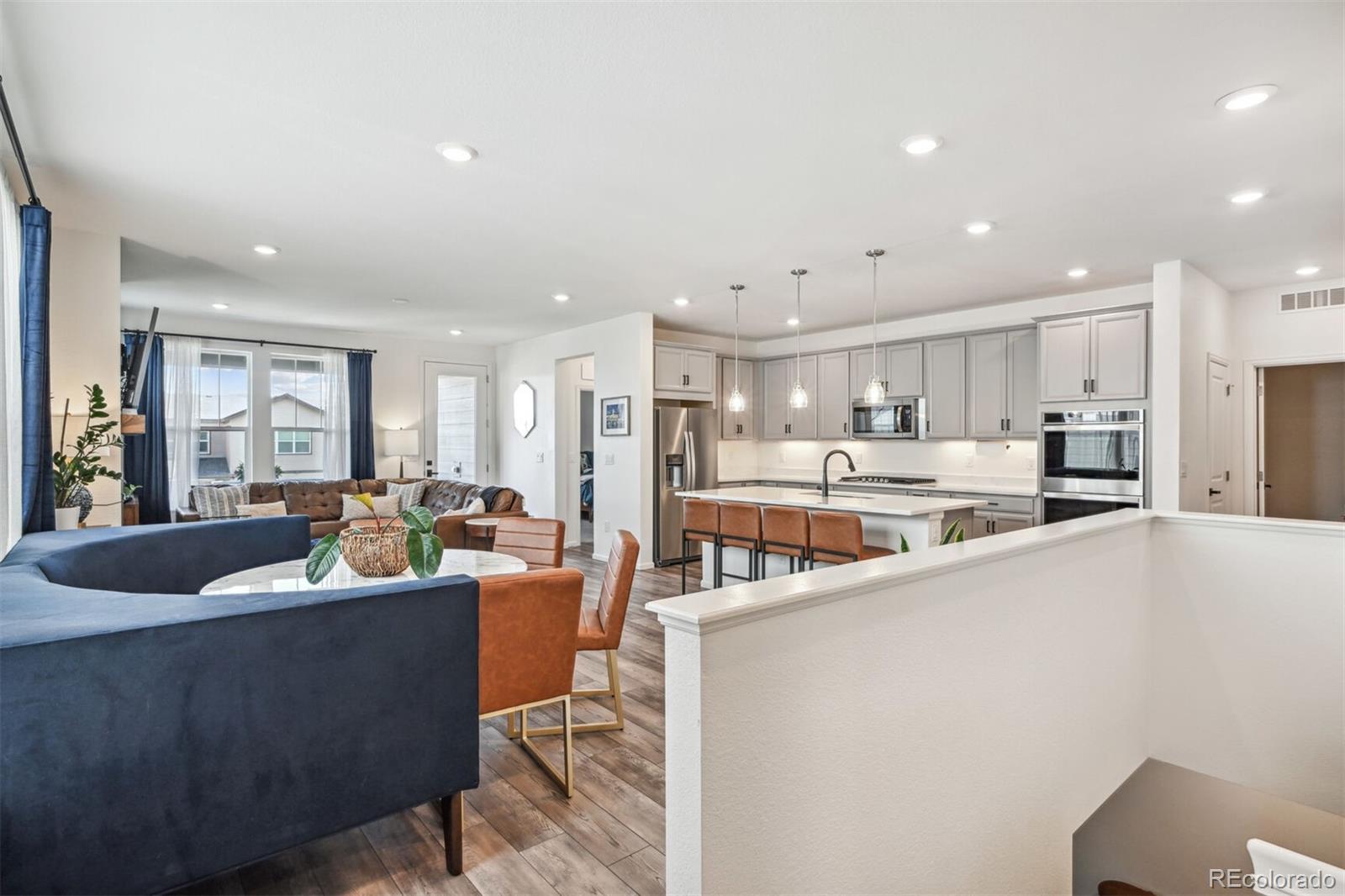 a living room with stainless steel appliances kitchen island furniture and a view of kitchen