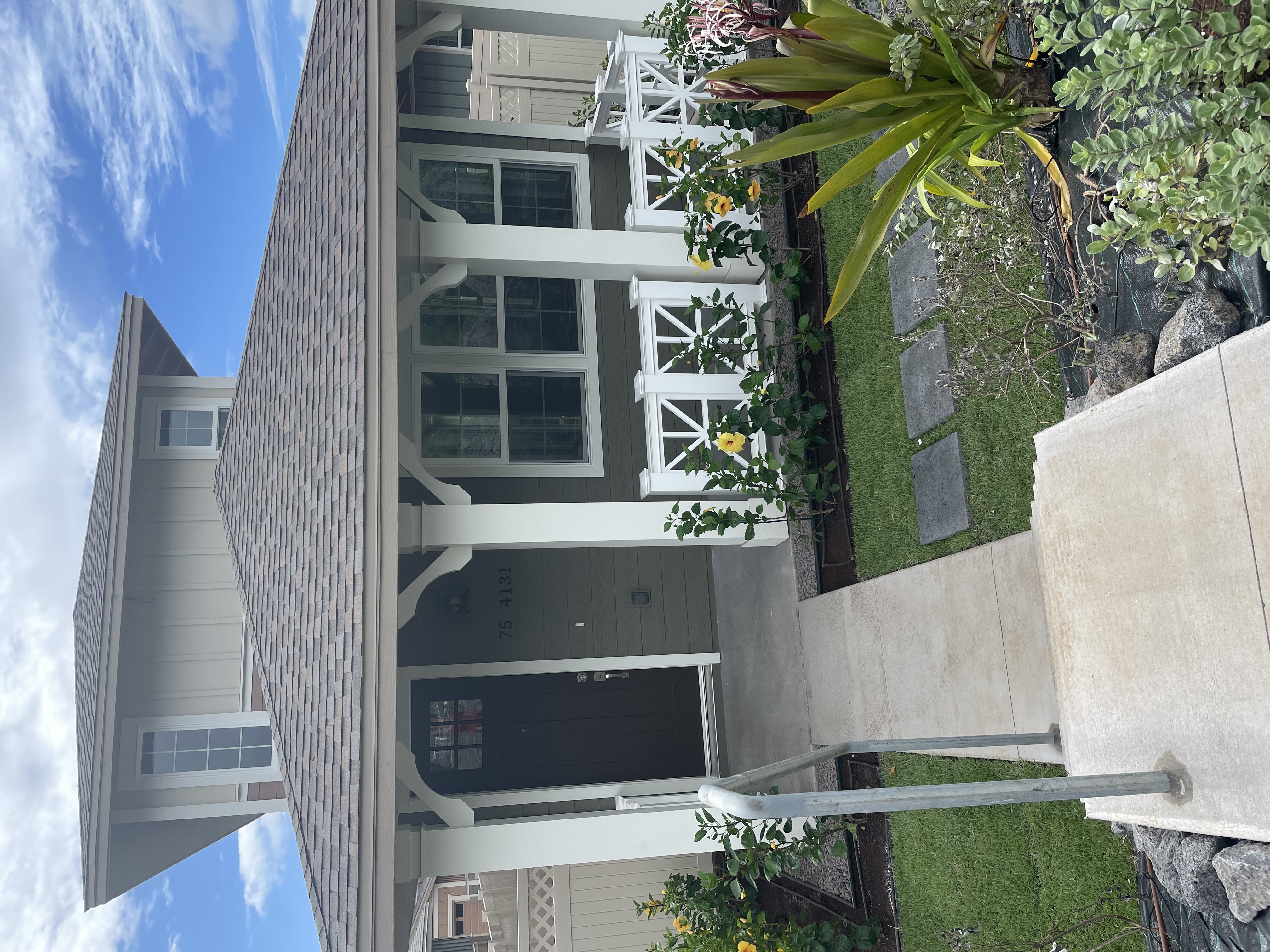 a front view of a house with a garden and plants