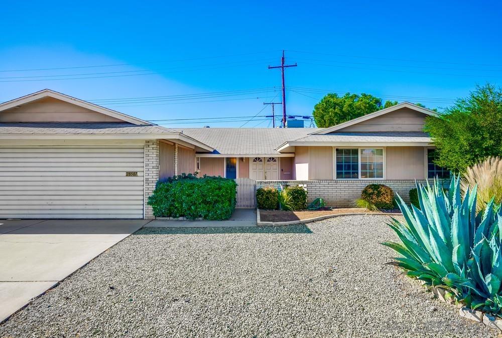 a view of a house with a small yard and potted plants