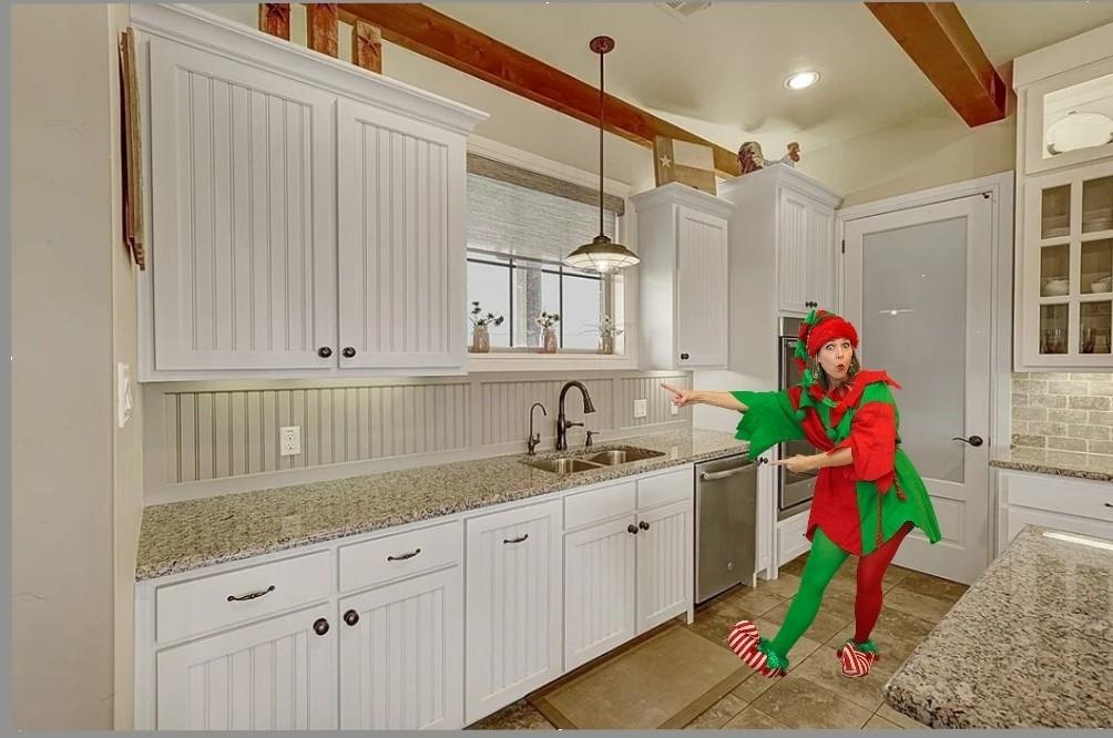 a kitchen with white cabinets and sink