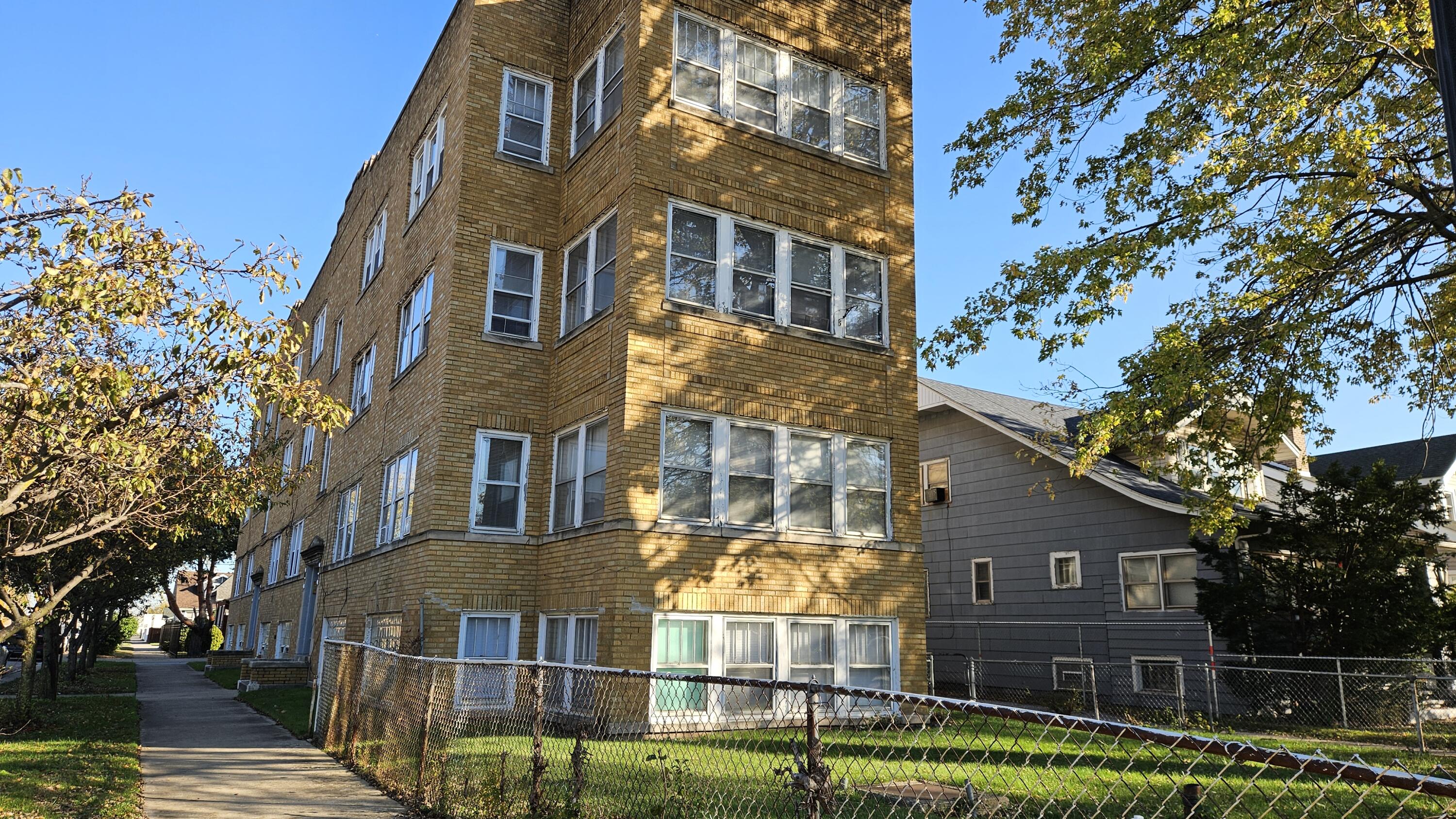 a front view of a residential apartment building with a yard