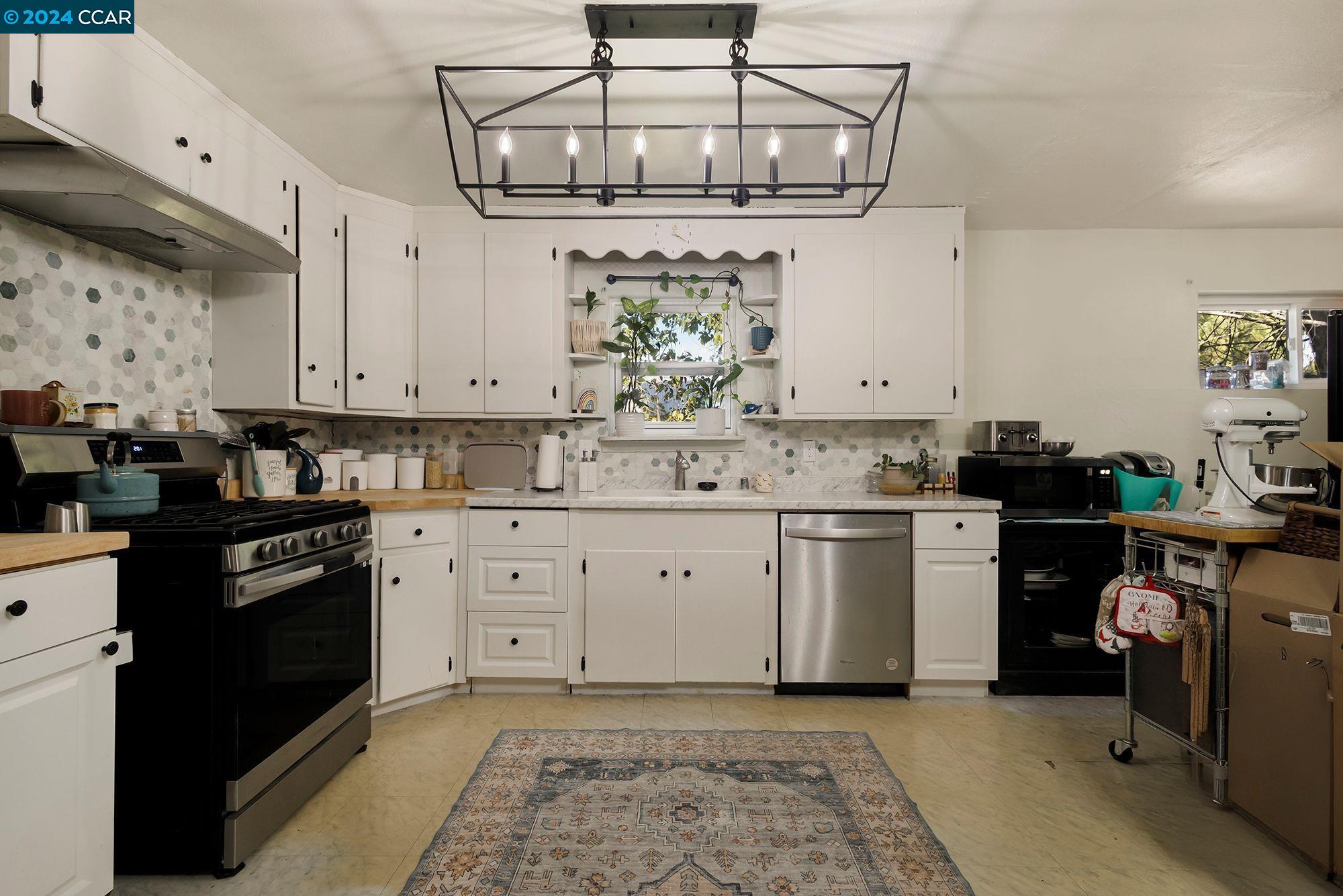 a kitchen with stainless steel appliances granite countertop a sink a stove and cabinets