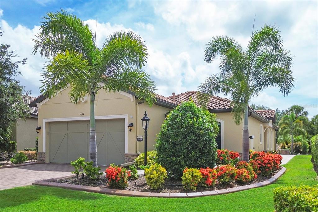 a view of a wooden house with a big yard and potted plants