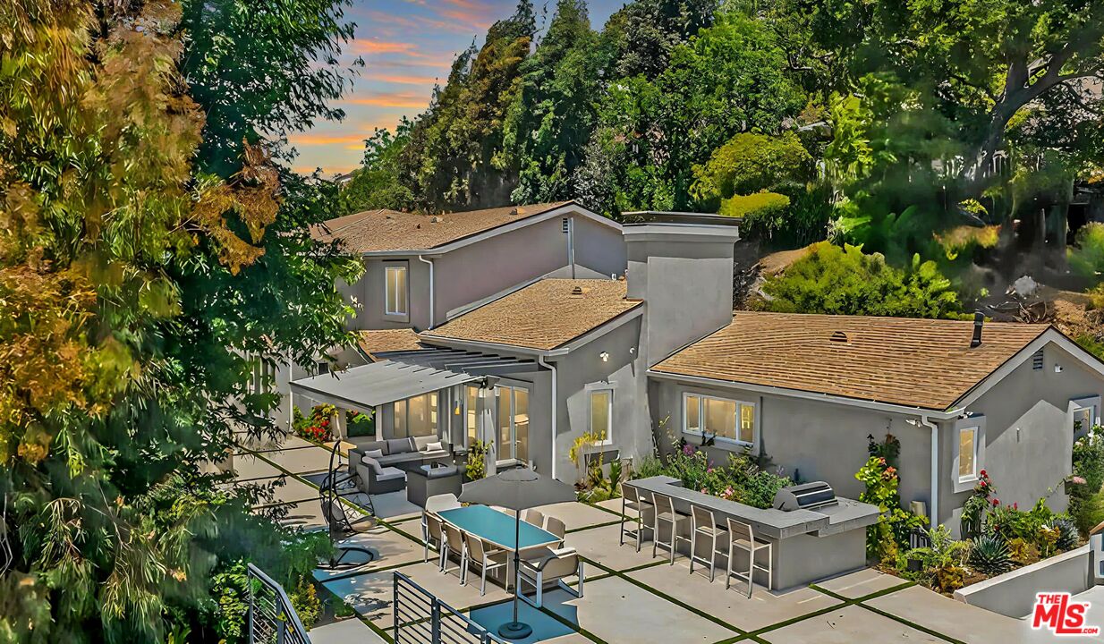 an aerial view of a house with table and chairs under an umbrella