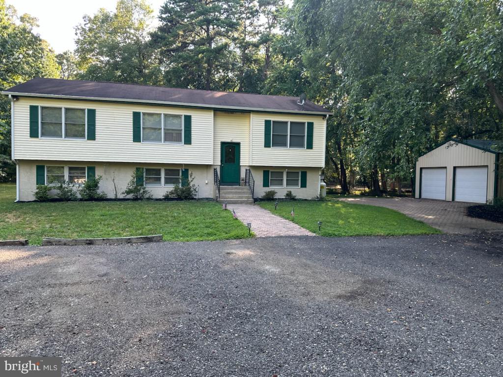 a view of house with a big yard and potted plants