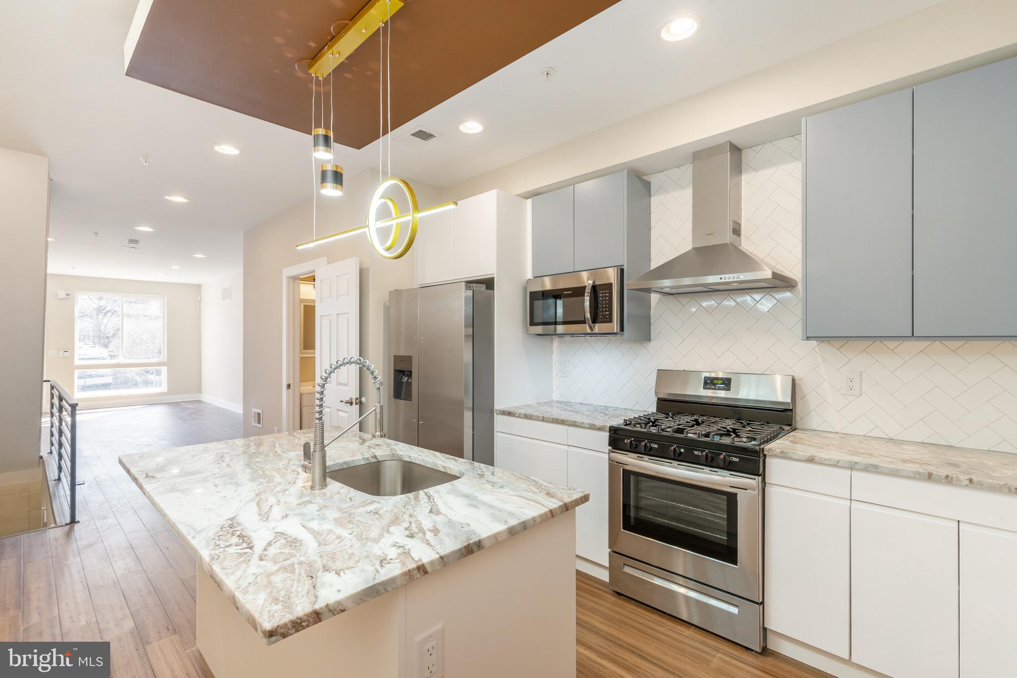 a kitchen with stainless steel appliances granite countertop a sink stove and refrigerator