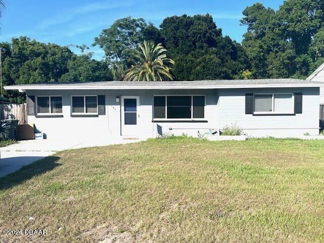 a front view of house with yard and trees around