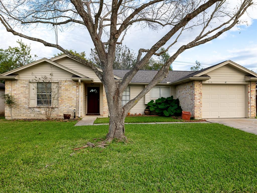 a view of a yard in front of a house with large trees