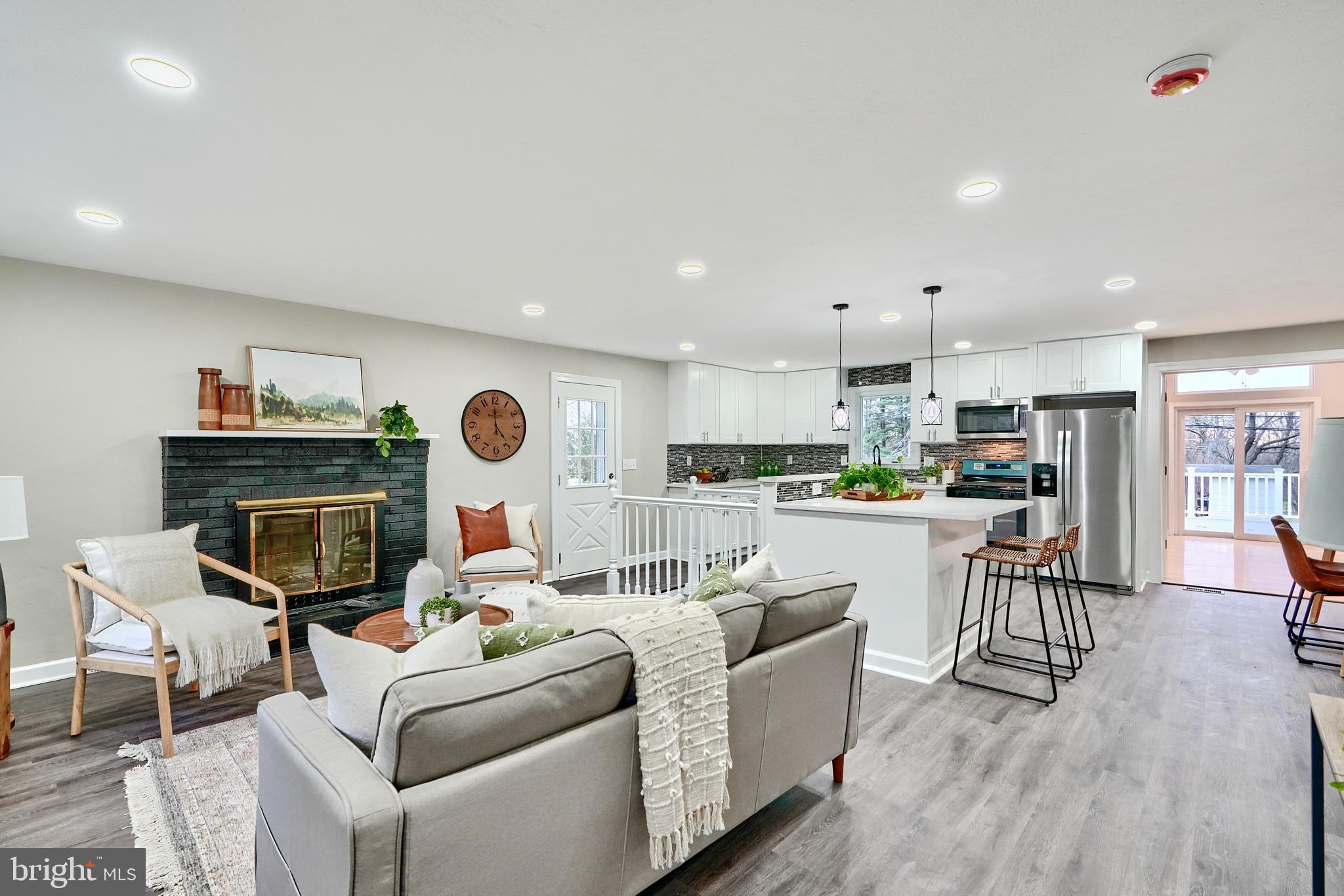 a living room with fireplace furniture and a kitchen view