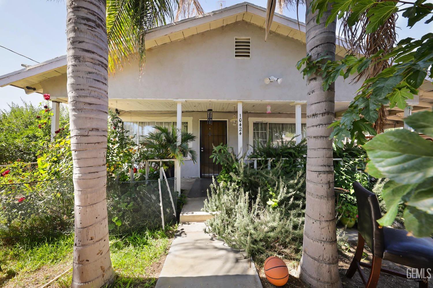 a front view of house with a yard and potted plants