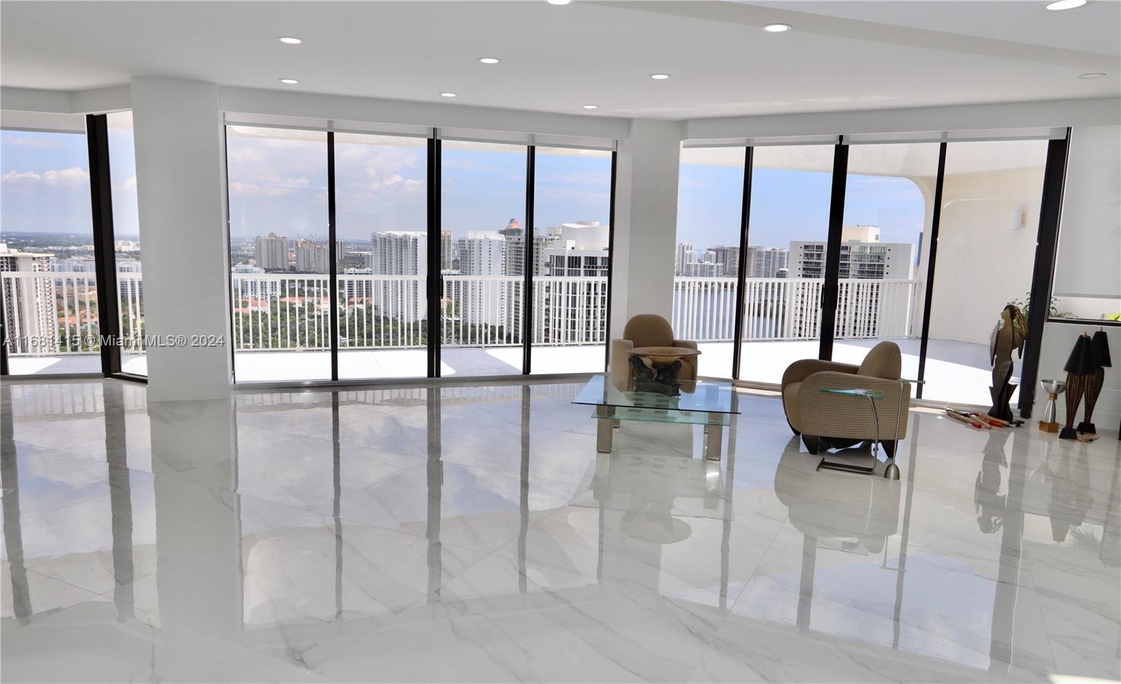 a living room with furniture and floor to ceiling windows