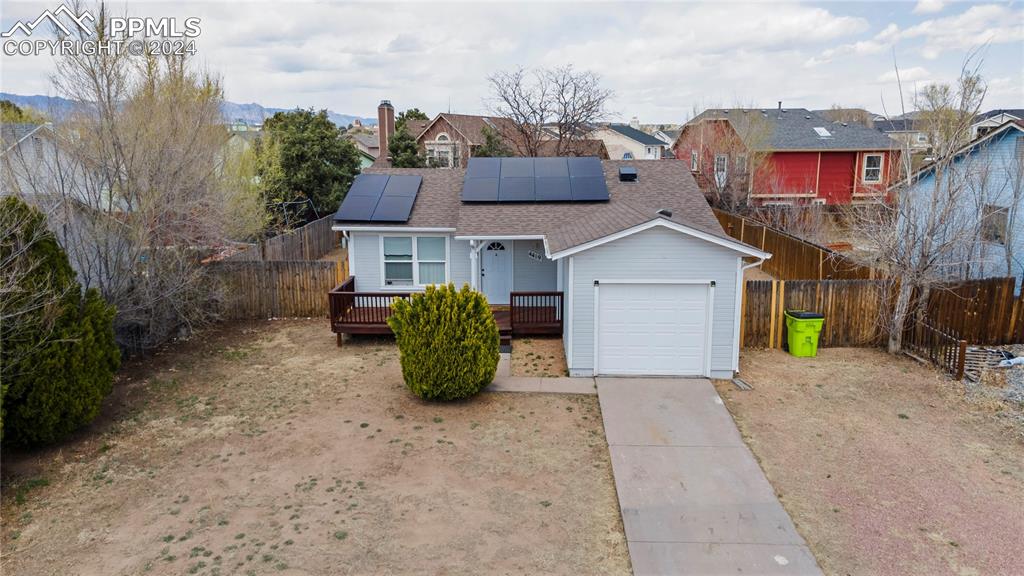 View of front of home with solar panels and a garage