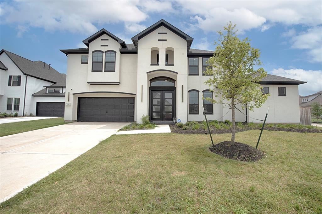 a front view of a house with a yard and garage