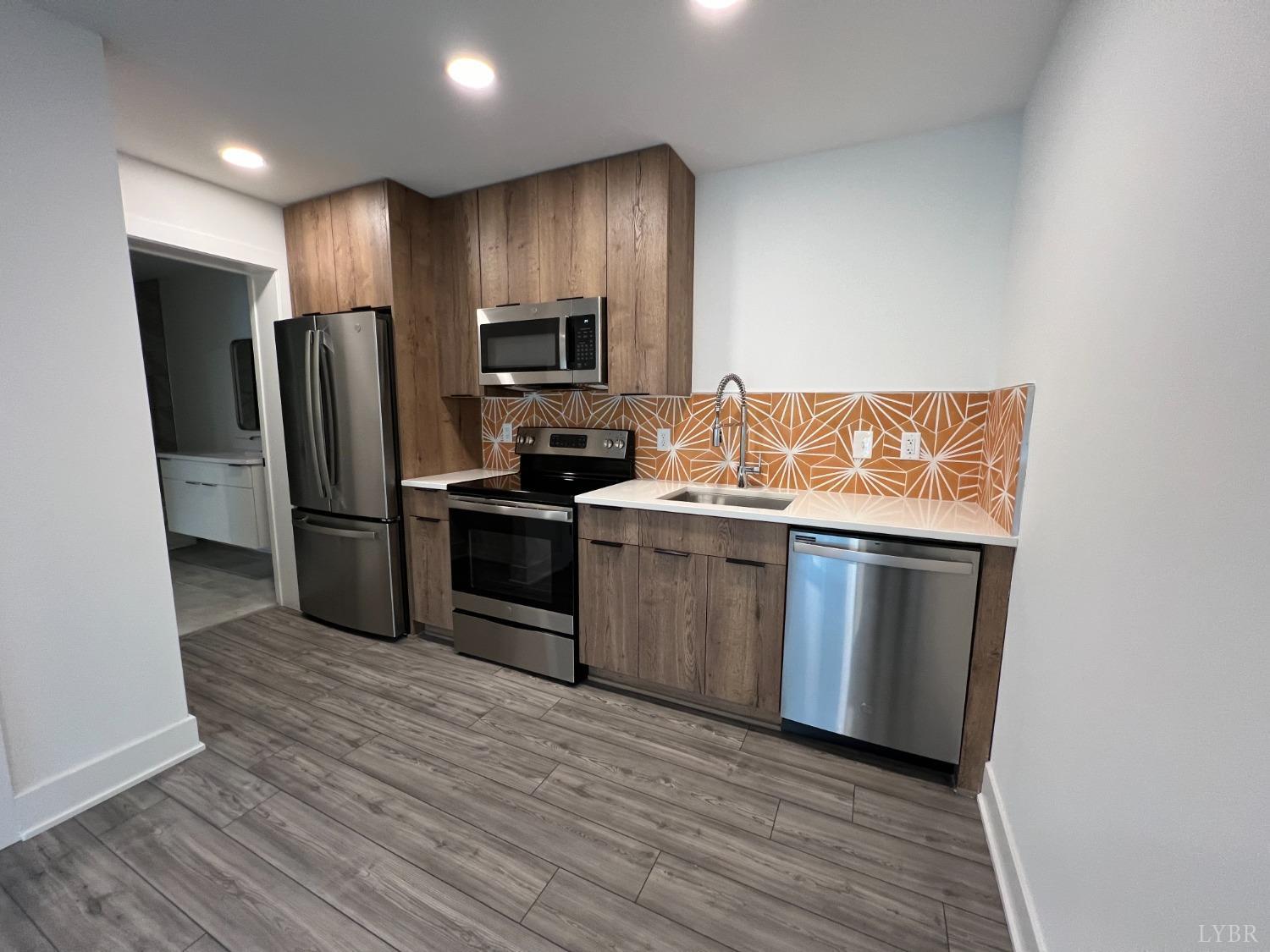 a kitchen with stainless steel appliances a refrigerator stove and microwave