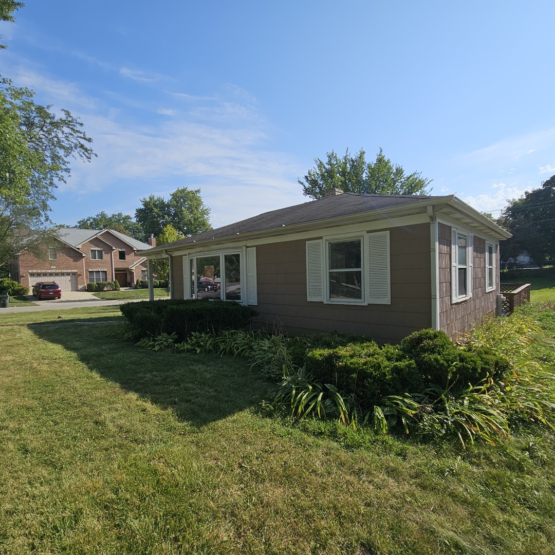 a view of backyard of house with green space