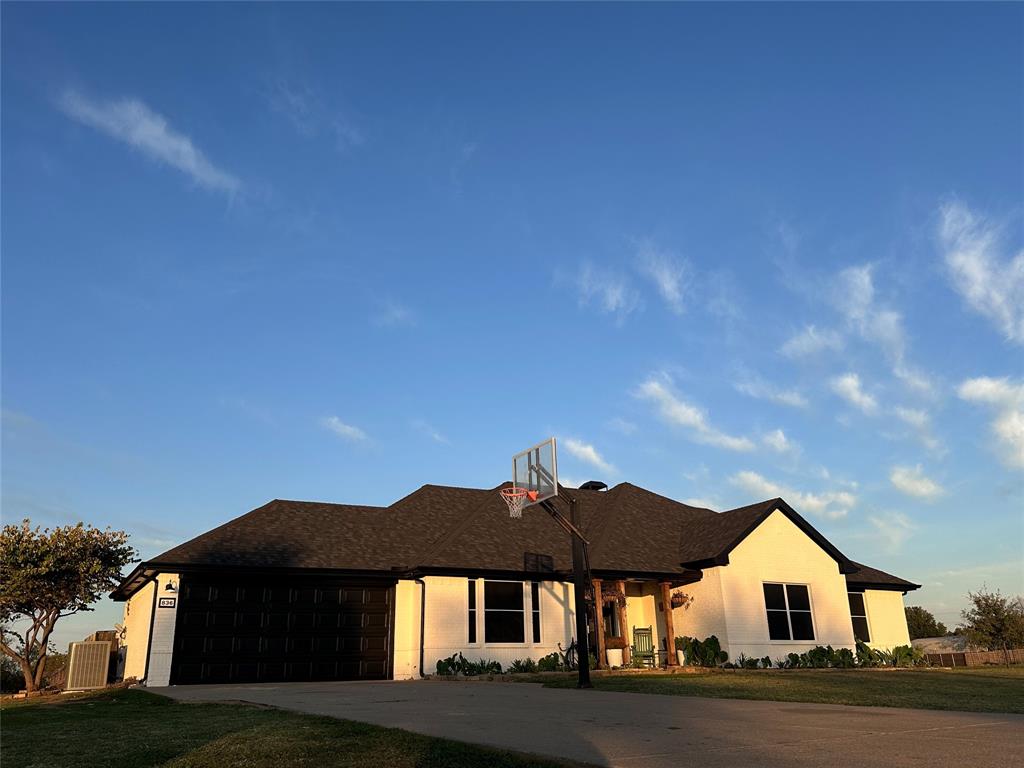 a front view of house with yard and trees in the background