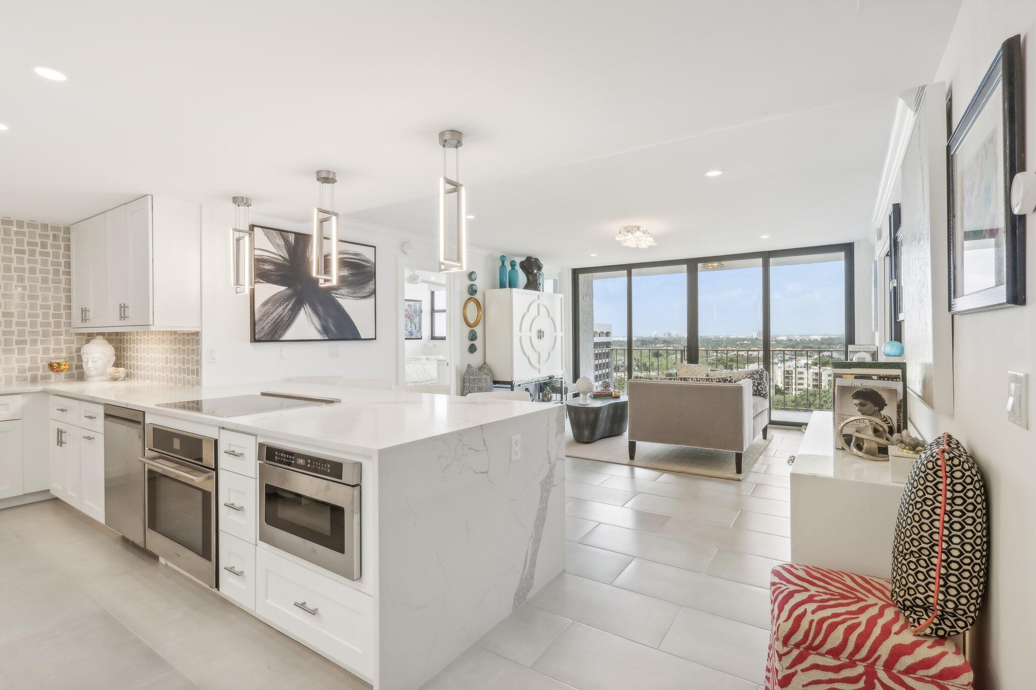 a open kitchen with stainless steel appliances kitchen island granite countertop a stove and a view of living room