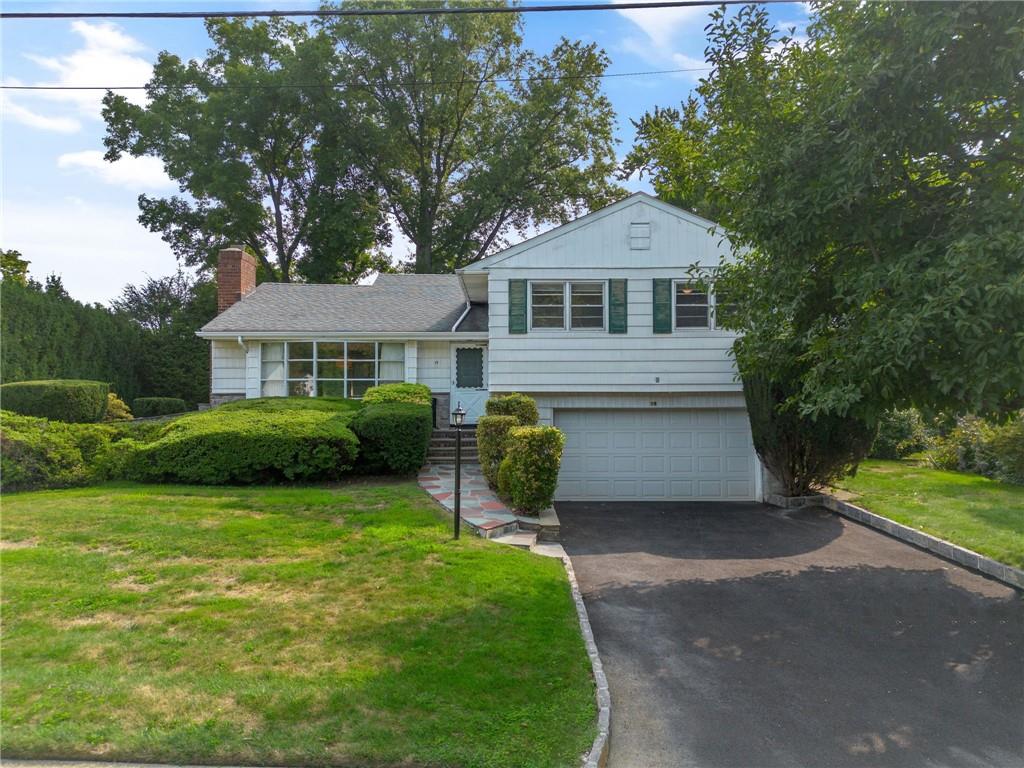 Split level home with a garage and a front lawn