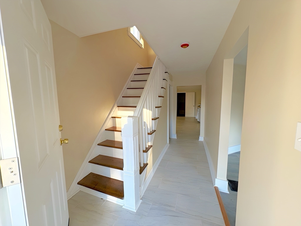 a view of entryway and hall with wooden floor