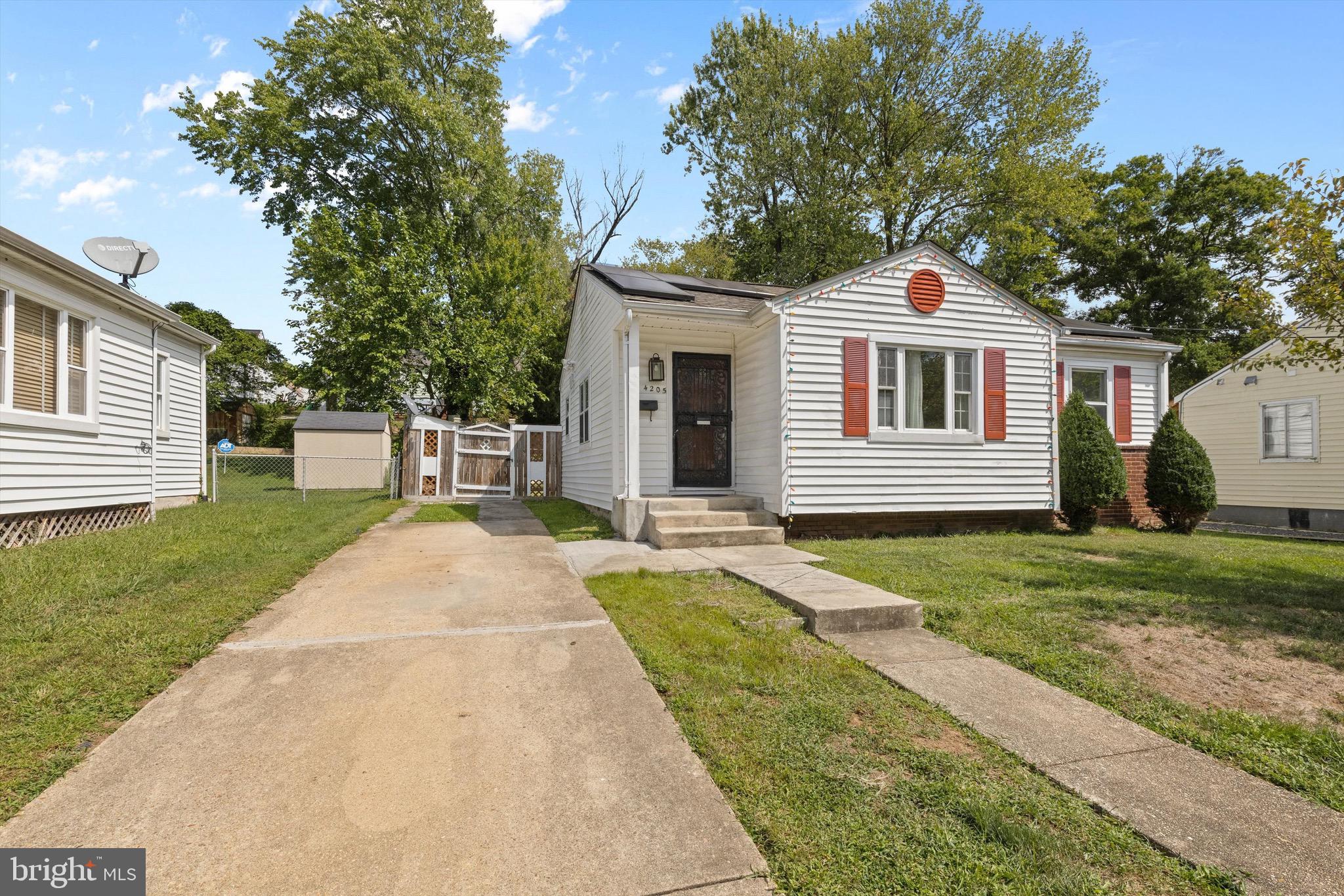 a front view of a house with a yard and trees