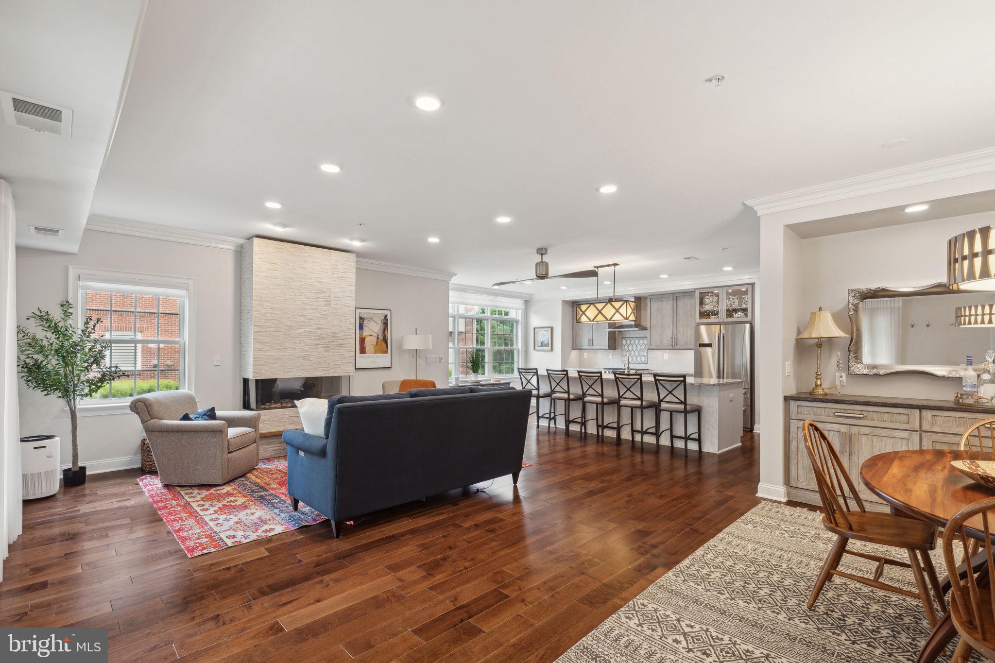 a living room with furniture a wooden floor and next to a window