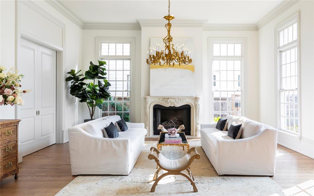 a living room with furniture a chandelier and a fireplace