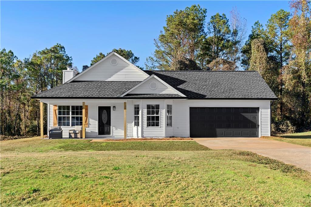 a front view of a house with yard and trees