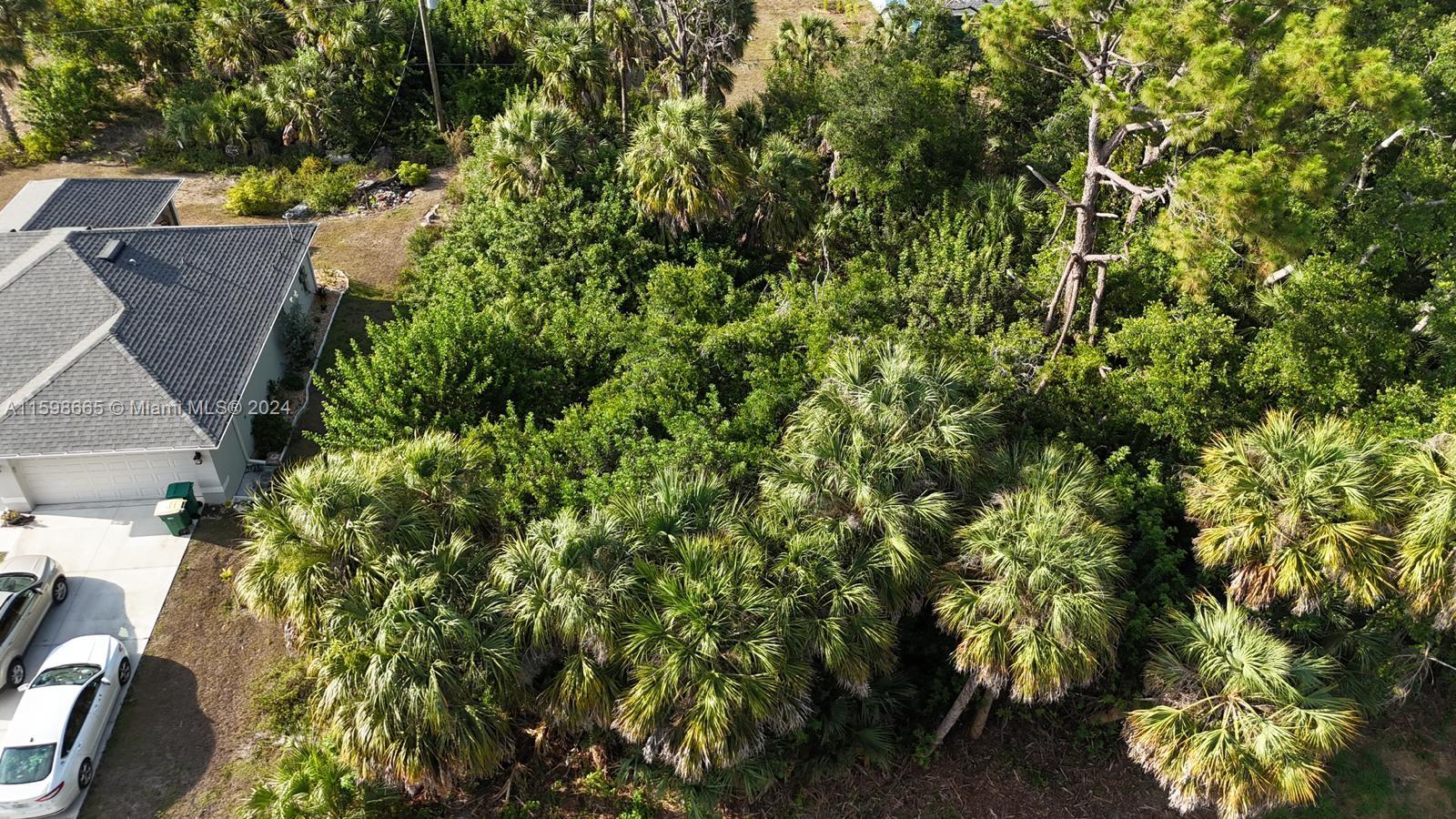 an aerial view of residential house with outdoor space and trees all around