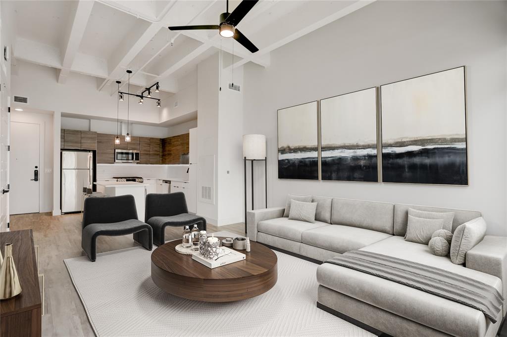 a living room with furniture kitchen view and a large window