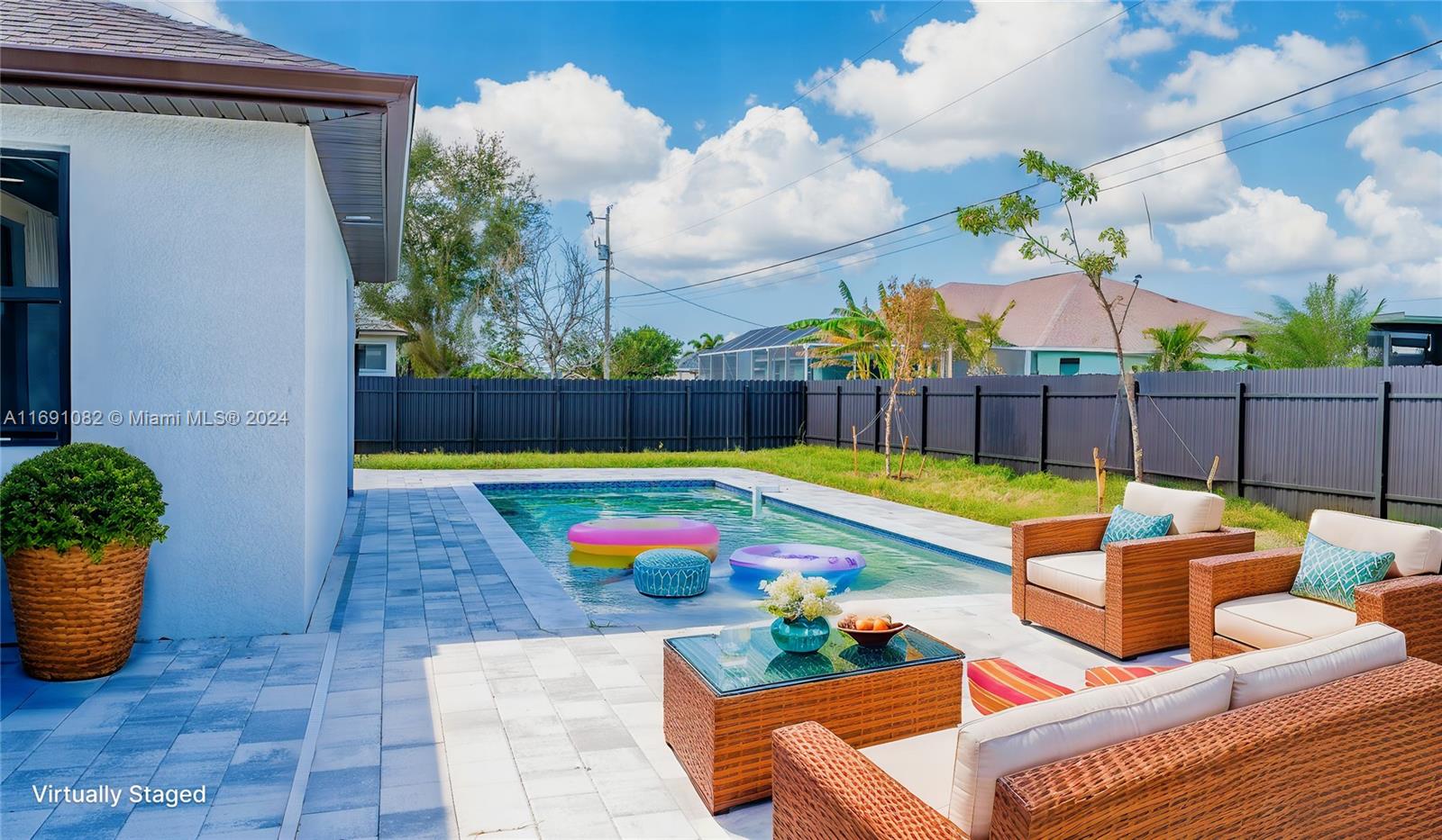 a view of swimming pool with seating space and yard in the back