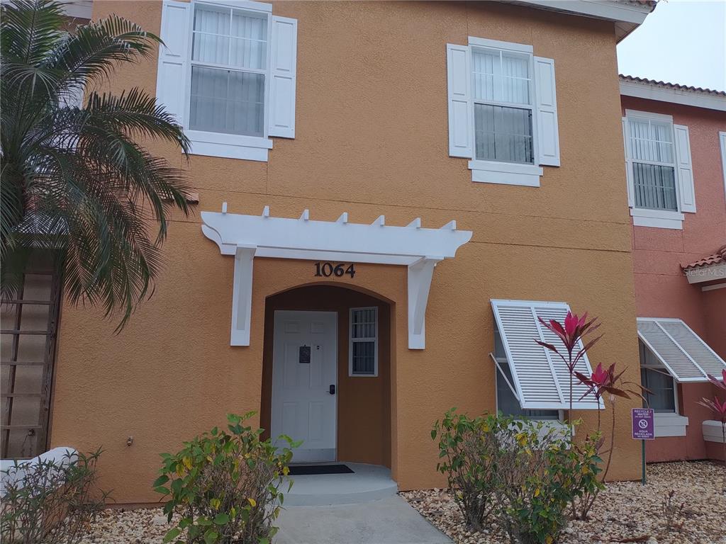 a front view of a house with plants