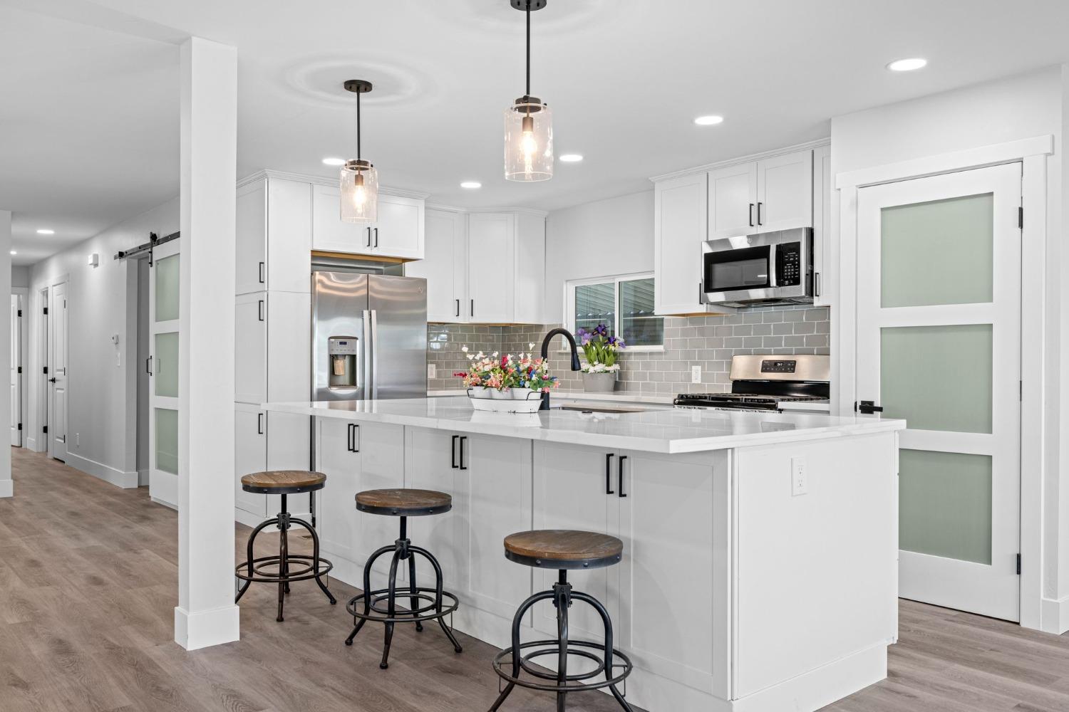 a kitchen with kitchen island white cabinets and stainless steel appliances